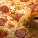 A ball of freshly made easy pizza dough on a floured surface, ready for rolling.