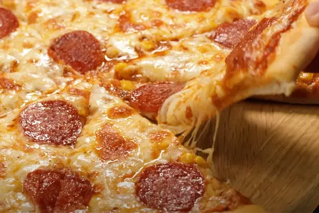A ball of freshly made easy pizza dough on a floured surface, ready for rolling.