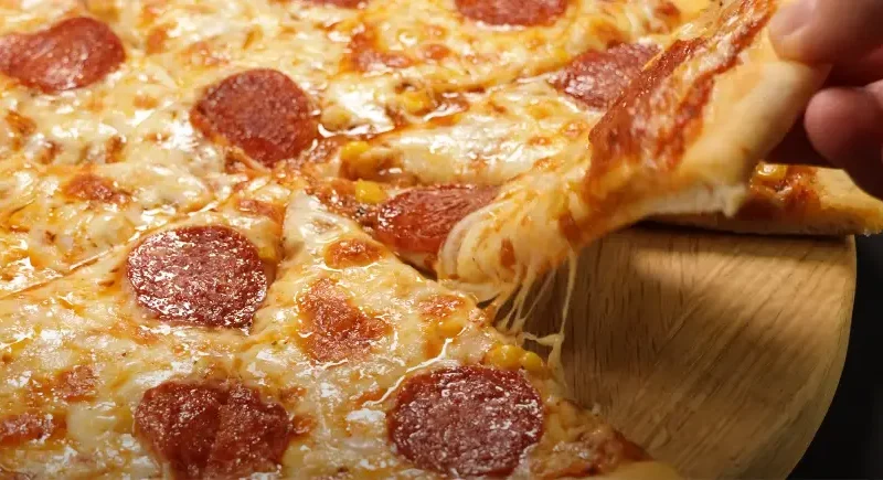 A ball of freshly made easy pizza dough on a floured surface, ready for rolling.