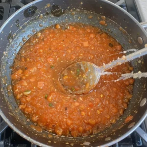 Sweet chili chicken pieces sizzling in sauce, topped with chopped scallions and sesame seeds